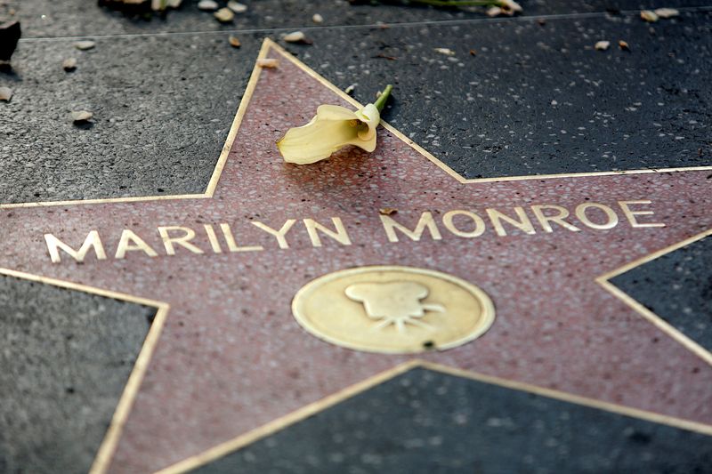 FILE PHOTO: A flower lays atop the Hollywood Walk of Fame star for the late actress Marilyn Monroe in Hollywood August 5, 2012. A memorial service was held in Los Angeles to mark the 50th anniversary of Monroe's death. REUTERS/Krista Kennell/File Photo