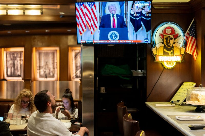 A customer watches U.S. President Donald Trump address the nation on the Iran crisis from the White House in Washington, D.C., on screen at Brooklyn Diner in Times Square, New York, U.S., April 1, 2026. REUTERS/David Dee Delgado/File Photo