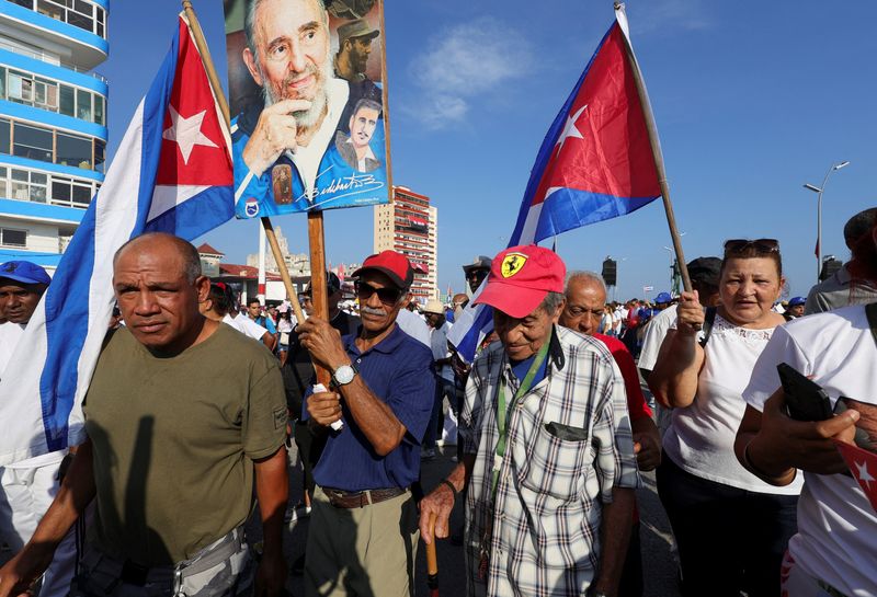 People carry Cuba's national flag and images of Cuba's late President Fidel Castro during the May Day rally, in Havana, Cuba May 1, 2026. REUTERS/Claudia Daut