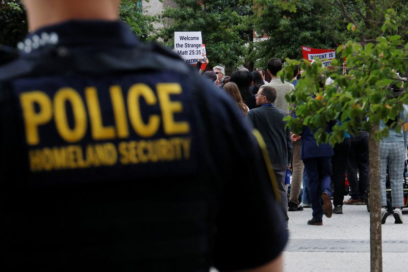 Homeland Security police officer stands behind a press conference called by Boston Mayor Michelle Wu to respond to a letter from U.S. Attorney General Pam Bondi demanding that Boston lift its sanctuary city policies, in Boston, Massachusetts, U.S., August 19, 2025.  A sanctuary city is a jurisdiction that has laws and policies that limit or prevent local law enforcement from assisting federal officers with civil immigration arrests. REUTERS/Brian Snyder