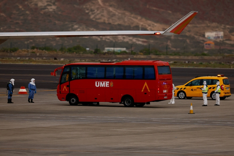 A bus with U.S. passengers of the cruise ship MV Hondius, which was affected by a hantavirus outbreak, parks near a plane bound for the United States at Tenerife Sud airport, Canary Islands, Spain, May 10, 2026. REUTERS/Borja Suarez