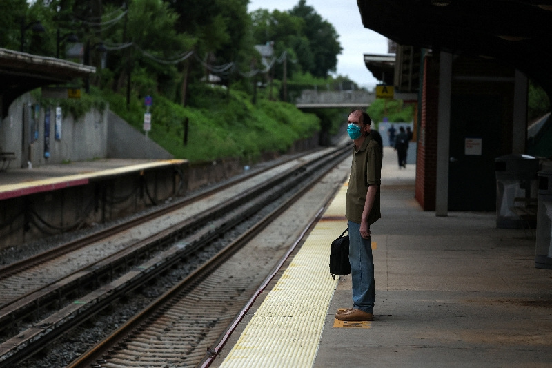 A commuter stands in front of empty train tracks at the Bayside station, a Long Island Rail Road station, as commuters wait for delayed trains in the Queens borough of New York City, U.S., August 1, 2025. REUTERS/Shannon Stapleton