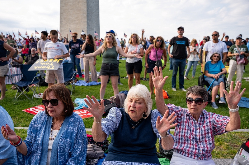 Women hold their hands up in worship near the Washington Monument during a worship service, Roots of Revival’, ahead of the "Rededicate 250: National Jubilee of Prayer, Praise and Thanksgiving" event aimed to celebrate America's 250th birthday, in Washington, D.C. , U.S. May 16, 2026.  REUTERS/Seth Herald