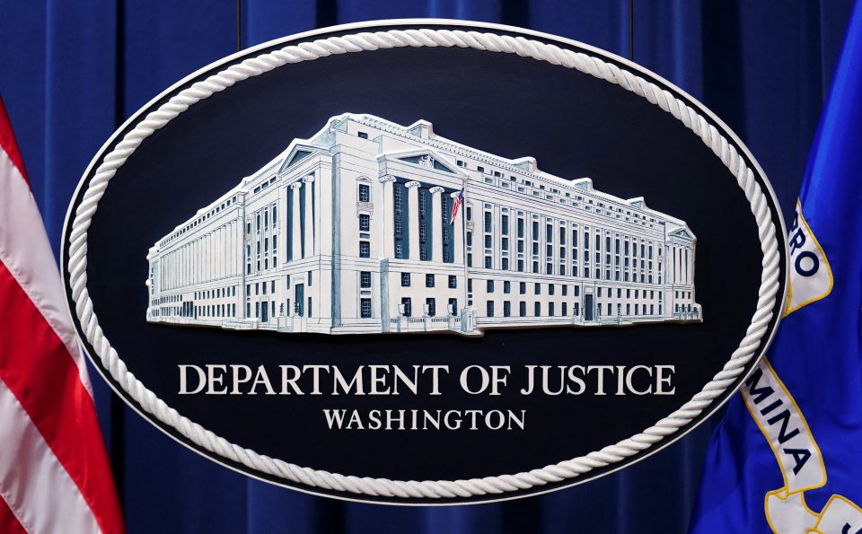 A U.S. Justice Department logo or seal showing Justice Department headquarters, known as "Main Justice," is seen behind the podium in the Department's headquarters briefing room in Washington, January 24, 2023.  REUTERS/Kevin Lamarque