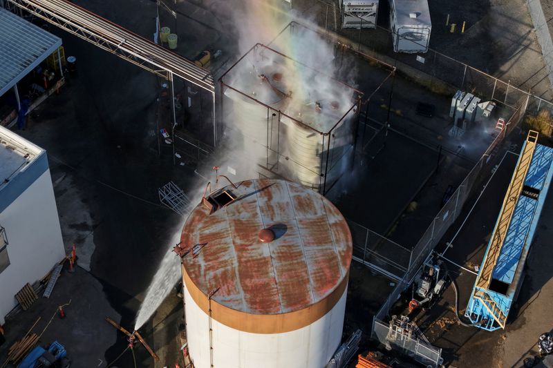 A drone picture shows water being sprayed on a tank as a chemical incident involving a failing tank of flammable liquid called methyl methacrylate, used in the aerospace industry, has forced an evacuation in the surrounding area in Garden Grove, California, U.S. May, 22, 2026. REUTERS/ Caroline Brehman