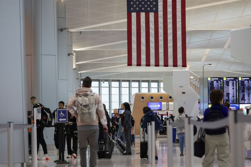 People walk at Newark Liberty International Airport, in Newark, New Jersey,  U.S., March 23, 2026. REUTERS/Jeenah Moon/File Photo