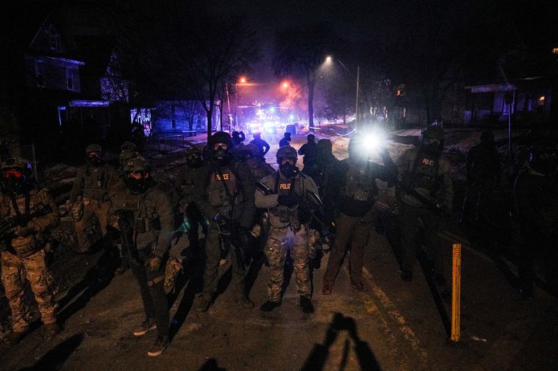 Federal agents stand guard, as tensions rise after federal law enforcement agents were involved in a shooting incident, a week after a U.S. Immigration and Customs Enforcement (ICE) agent fatally shot Renee Nicole Good, in north Minneapolis, Minnesota, U.S., January 14, 2026. REUTERS/Ryan Murphy/File Photo