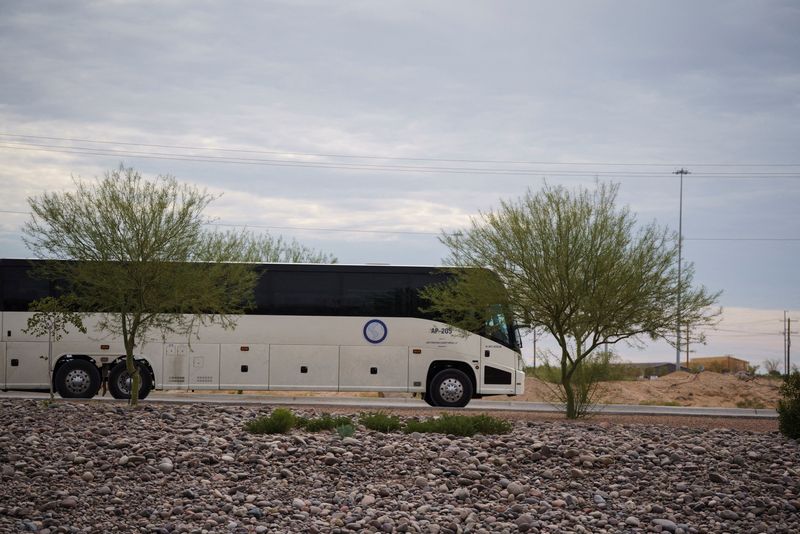 FILE PHOTO: A bus used to transport detainees of Immigration and Customs Enforcement exits Camp East Montana, the new ICE detention facility being built to house up to 5,000 migrants, which is under construction at Fort Bliss in El Paso, Texas, U.S., August 17, 2025.  REUTERS/Paul Ratje/File Photo