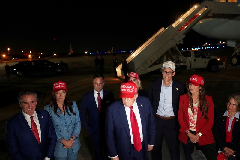 FILE PHOTO: U.S. President Donald Trump stands with U.S. Homeland Security Secretary Kristi Noem, Agriculture Secretary Brooke Rollins, Interior Secretary Doug Burgum, Representative Randy Feenstra (R-IA),  Representative Zach Nunn (R-IA), Rep. Mariannette Miller-Meeks (R-IA) and Representative Ashley Hinson (R-IA), upon arrival at Joint Base Andrews following a visit to Iowa, at Joint Base Andrews, Maryland, U.S. July 4, 2025. REUTERS/Nathan Howard/File Photo