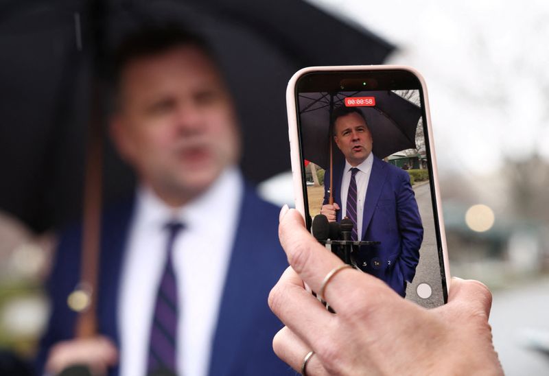 A reporter films with her phone as U.S. Federal Housing Finance Agency Director Bill Pulte speaks with reporters at the White House in Washington, D.C., U.S., January 9, 2026.  REUTERS/Kevin Lamarque