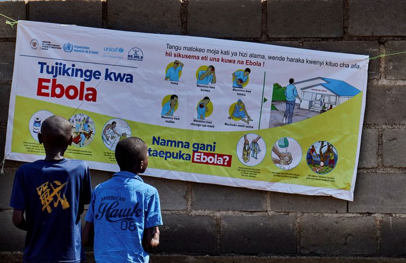 Congolese children Ibrah Asimwe and Alex Uketi read an advocacy poster as aid agencies intensify efforts to contain a new Ebola outbreak involving the Bundibugyo strain outbreak, in Bunia, Ituri province, Democratic Republic of Congo, May 20, 2026. REUTERS/Gradel Muyisa Mumbere/