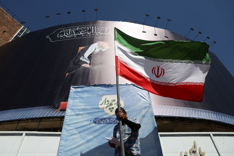A man holds an Iranian flag on a street, after U.S. and Iranian officials said they had reached a deal to end their war and reopen the Strait of Hormuz, in Tehran, Iran, June 15, 2026. Majid Asgaripour/WANA (West Asia News Agency) via REUTERS