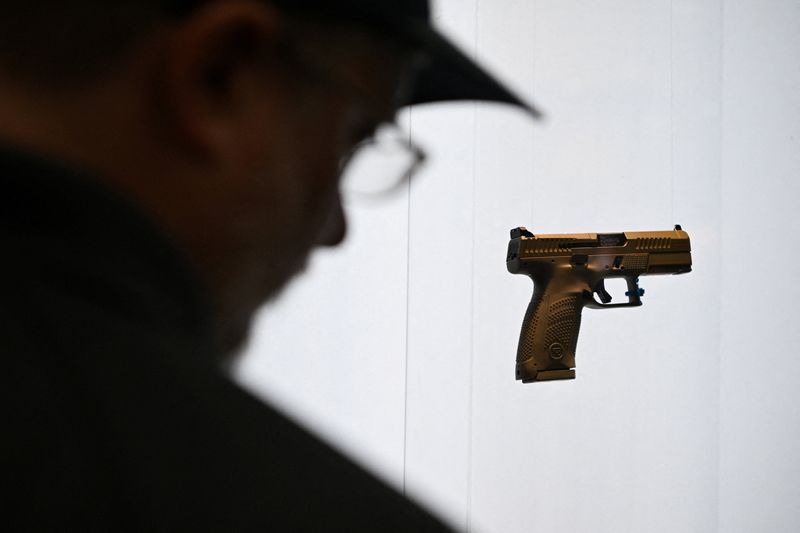 A person looks at a gun on display during the National Rifle Association’s (NRA) Annual Meetings and Exhibits in Houston, Texas, U.S. April 19, 2026. REUTERS/Callaghan O'Hare