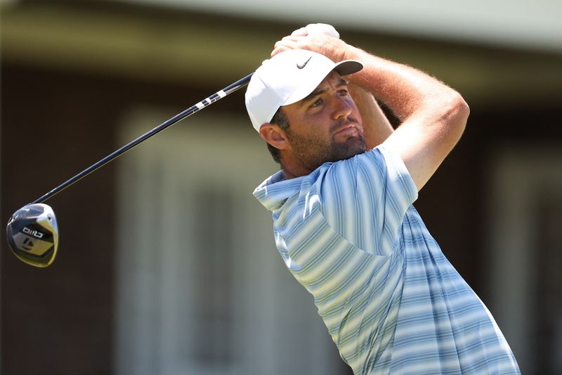 Jun 15, 2026; Southampton, New York, USA; Scottie Scheffler plays a tee shot on hole 14 during a practice round for the U.S. Open golf tournament. Mandatory Credit: Bill Streicher-Imagn Images