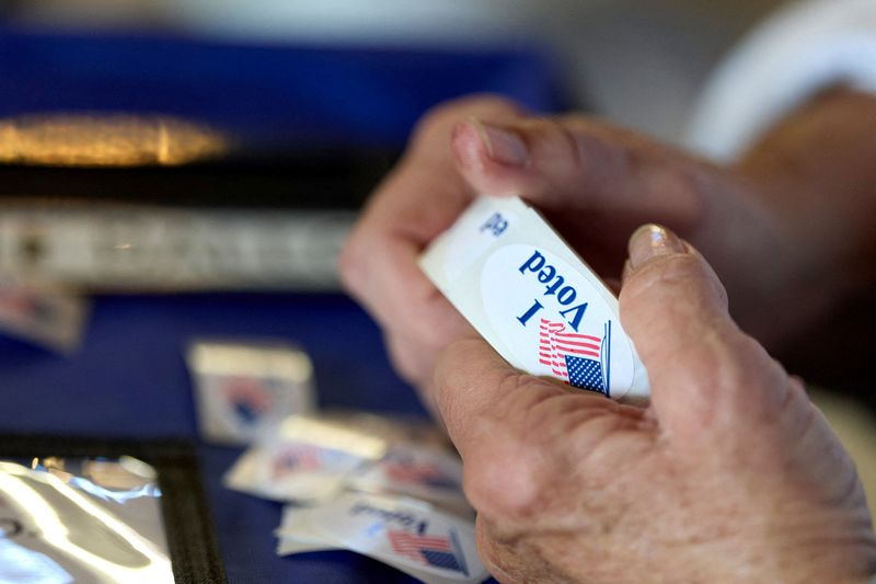 FILE PHOTO: A poll worker holds a roll of 'I voted' stickers at an El Dorado County polling station during California's special election on Proposition 50 in El Dorado Hills, California, U.S., November 4, 2025. REUTERS/Fred Greaves/File Photo