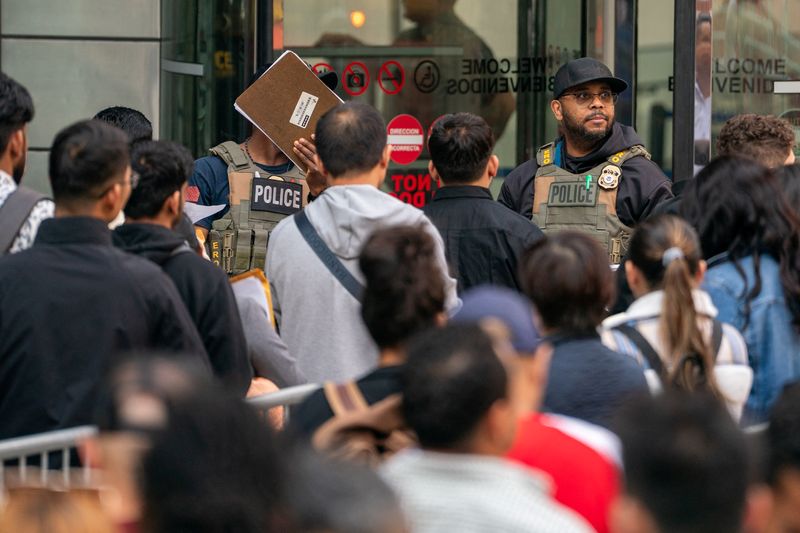 ICE agents speak to people lined up to enter the U.S. Immigration Court, in Manhattan, New York City, U.S., June 5, 2025. REUTERS/David 'Dee' Delgado