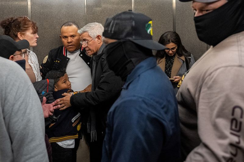 FILE PHOTO: Federal immigration officers surround a father and his son on an elevator during a targeted detainment at U.S. immigration court in Manhattan, in New York City, U.S., March 5, 2026. REUTERS/David 'Dee' Delgado/File Photo