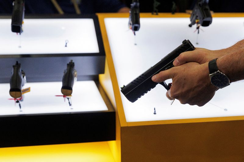 FILE PHOTO: A person tries out a handgun during the annual National Rifle Association (NRA) meeting in Dallas, Texas, U.S., May 17, 2024. REUTERS/Shelby Tauber/File Photo