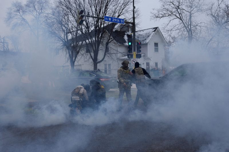 FILE PHOTO: Federal agents detain a person while they're surrounded by tear gas used to deter protesters, as immigration enforcement continues after a U.S. Immigration and Customs Enforcement (ICE) agent fatally shot Renee Nicole Good on January 7 during an immigration raid, in Minneapolis, Minnesota, U.S., January 21, 2026. REUTERS/Leah Millis/File Photo