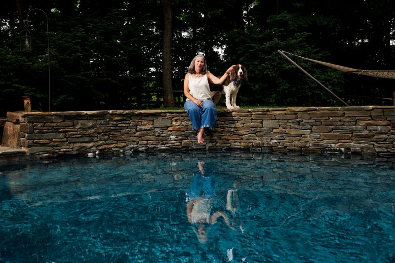 Betsy Halsey, 63, Democrat and retired teacher, poses for a portrait with her dog Jag, in Doylestown, Pennsylvania, U.S., June 10, 2026. REUTERS/Hannah Beier