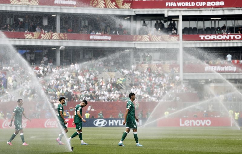 Soccer Football - FIFA World Cup 2026 - Group I - Senegal v Iraq - Toronto Stadium, Toronto, Canada - June 26, 2026 Iraq's Munaf Younus with teammates as the pitch is watered by sprinklers during a hydration break REUTERS/Benoit Tessier/File Photo