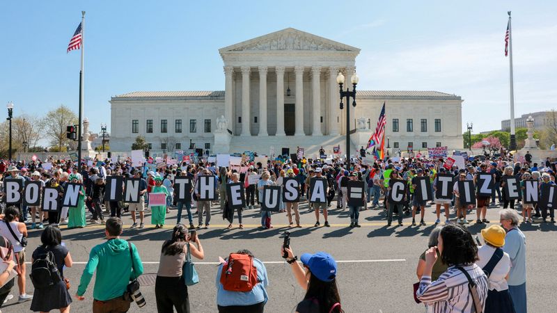 FILE PHOTO: Demonstrators hold letters making up the slogan "Born in the USA = citizen!" outside the U.S. Supreme Court building as the court hears oral arguments on the legality of the Trump administration's effort to limit birthright citizenship for the children of immigrants, in Washington, D.C., U.S., April 1, 2026. REUTERS/Kylie Cooper/File Photo