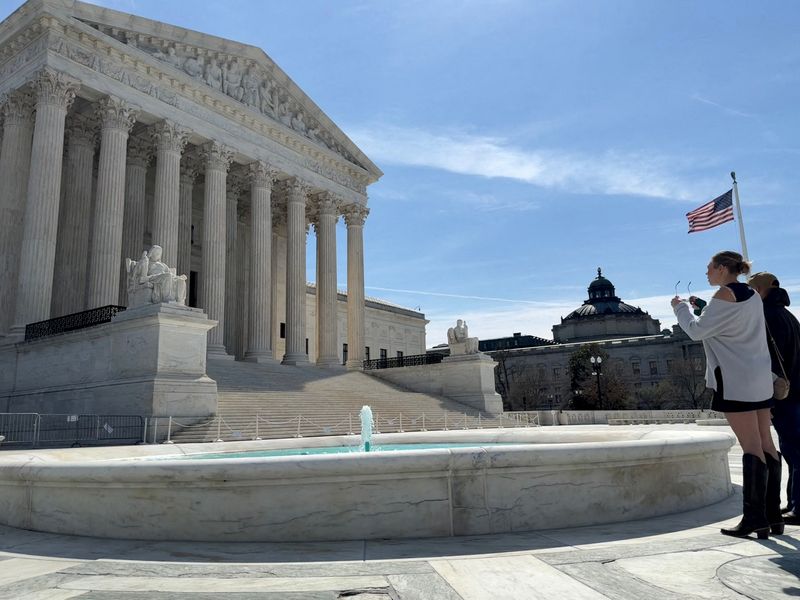 FILE PHOTO: People look at the U.S. Supreme Court building in Washington, D.C., U.S., March 14, 2026. REUTERS/Will Dunham/File Photo