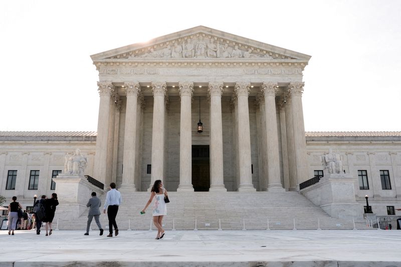 People walk in front of the Supreme Court building, as the court is set to issue the final rulings of its nine-month term, in Washington, D.C., U.S., June 30, 2026. REUTERS/Cheney Orr
