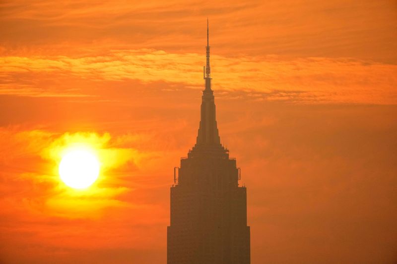 The sun rises next to The Empire State Building through a cover of wildfire smoke, as viewed from Hoboken, New Jersey, U.S., July 17, 2026. REUTERS/Eduardo Munoz