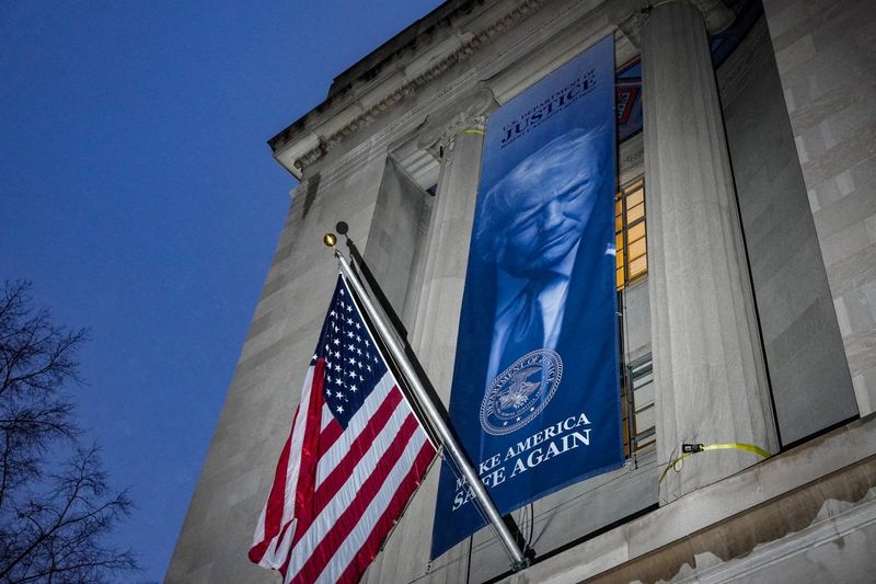 FILE PHOTO: A new banner depicting U.S. President Donald Trump is put up on the Department of Justice building in Washington, D.C., U.S., February 20, 2026.  REUTERS/Ken Cedeno/File Photo