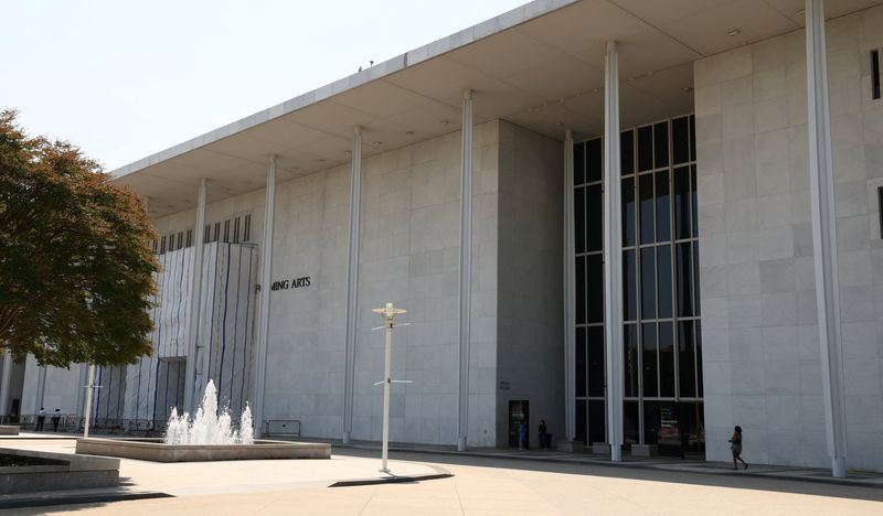 A woman walks along the front of the John F. Kennedy Center for the Performing Arts on a day when the center’s board voted to inscribe onto the building “Restored and Renovated by President Donald J. Trump”,  in Washington, D.C., U.S., August 13, 2026. REUTERS/Kevin Lamarque
