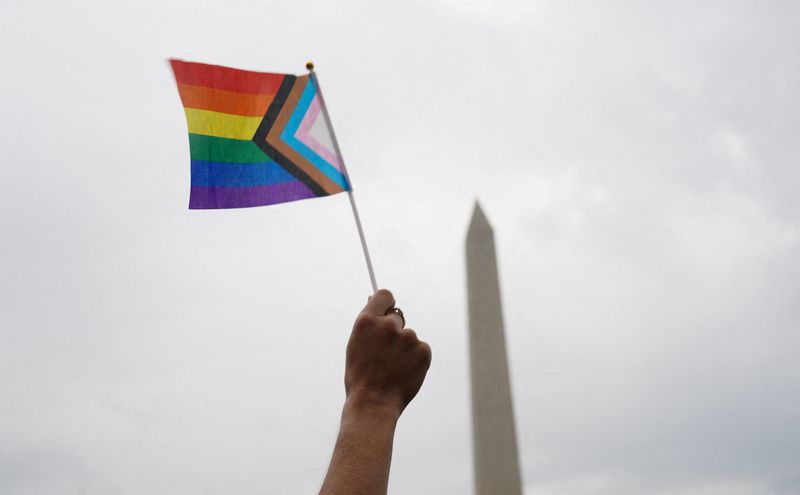 FILE PHOTO: A person holds a Progress Pride Flag during the "International Rally + March on Washington for Freedom" in support of LGBTQ+ rights as part of WorldPride in Washington, D.C., U.S., June 8, 2025. REUTERS/Gabriel V. Cardenas/File Photo