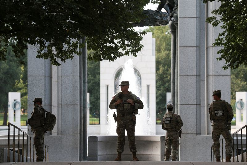 Members of the National Guard stand near the World War II Memorial, after the pool was reportedly vandalized with soap and graffiti in Washington, D.C., U.S., August 13, 2026. REUTERS/Kylie Cooper