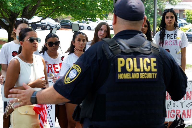 A Homeland Security officer speaks to classmates and relatives gathered outside the Immigration court as an immigration judge held a bond hearing for Marcelo Gomes da Silva, a high school student from Milford who was detained by Immigration and Enforcement (ICE), in Chelmsford, Massachusetts, U.S., June 5, 2025.   REUTERS/Brian Snyder