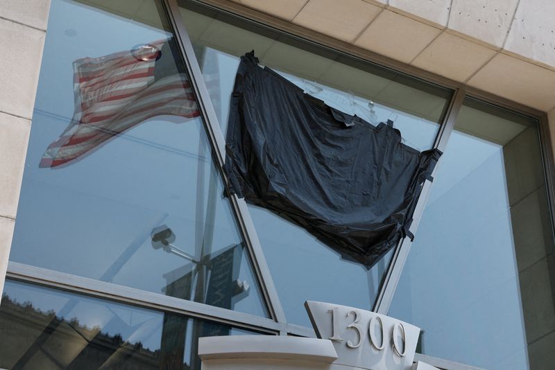 FILE PHOTO: A U.S. flag is reflected in the windows of the shuttered former offices of the U.S. Agency for International Development (USAID) in Washington, D.C., U.S., July 22, 2025. REUTERS/Jonathan Ernst/File Photo