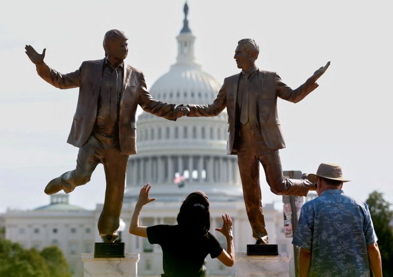 Visitors look up at a pop-up statue depicting U.S. President Donald Trump and  disgraced financier and sex offender Jeffrey Epstein dancing together near the U.S. Capitol in Washington, D.C., U.S., September 23, 2025. REUTERS/Kevin Lamarque