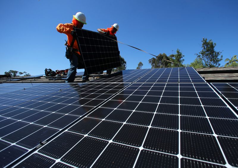 Solar installers place solar panels on the roof of a residential home in Scripps Ranch, San Diego, California, U.S. October 14, 2016. REUTERS/Mike Blake