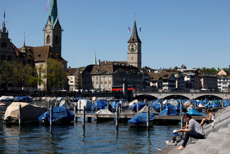 FILE PHOTO: People enjoy a warm day along the shore of the river Limmat in Zurich, Switzerland, April 30, 2025.  REUTERS/Stefan Wermuth/File Photo