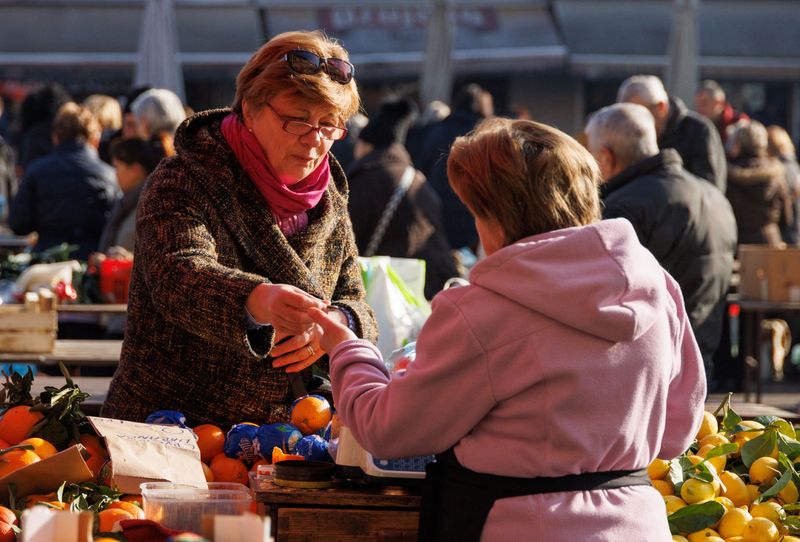 A woman is seen paying for fruits at Dolac market in Zagreb, Croatia, January 14, 2023. REUTERS/Antonio Bronic/File Photo