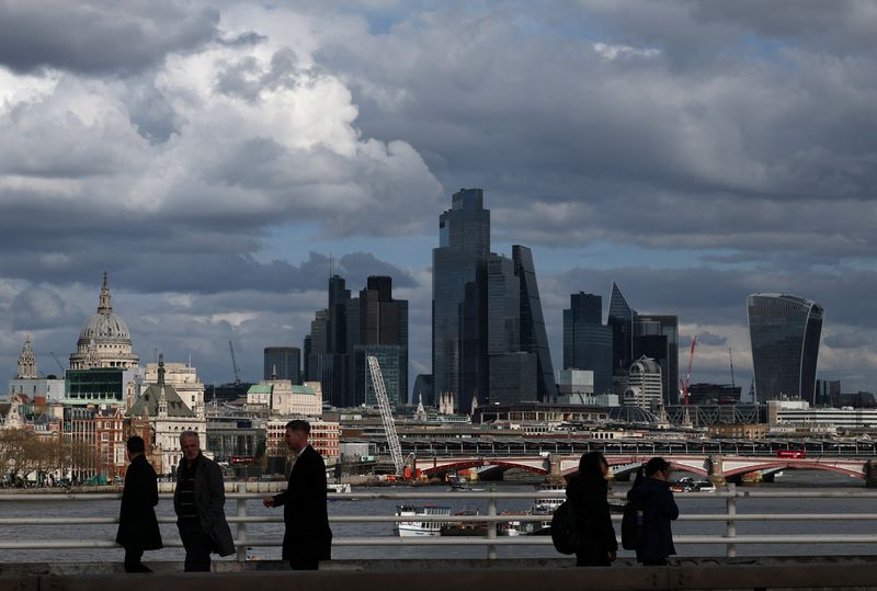 FILE PHOTO: People walk across Waterloo Bridge with skyscrapers of the City of London financial district and St Paul’s Cathedral seen behind, in London, Britain, March 28, 2025. REUTERS/Toby Melville/File Photo