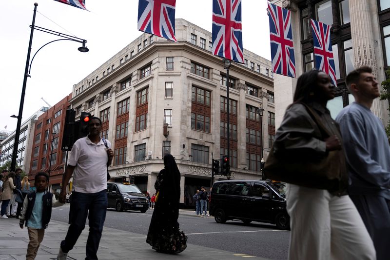 FILE PHOTO: Pedestrians walk past the Marble Arch branch of British retailer Marks & Spencer Plc in central London, Britain, May 18, 2025. REUTERS/Carlos Jasso/File Photo