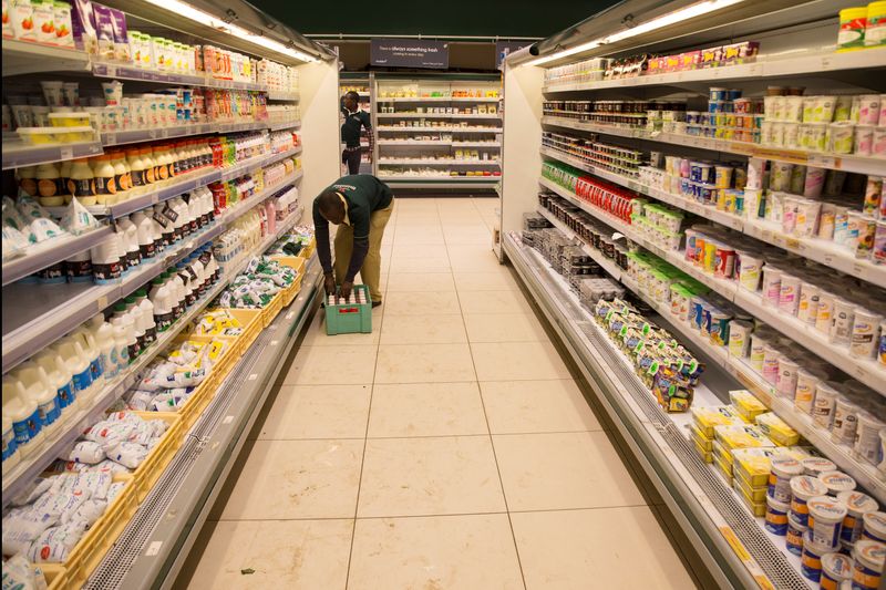 FILE PHOTO: An employe restocks the dairy products section at a supermarket in Nairobi, Kenya May 8, 2017. Picture taken May 8, 2017. REUTERS/Baz Ratner/File Photo
