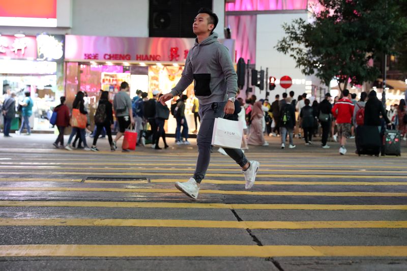 A shopper runs across the road outside Causeway Bay shopping mall in Hong Kong, China, December 26, 2019. REUTERS/Lucy Nicholson/File Photo
