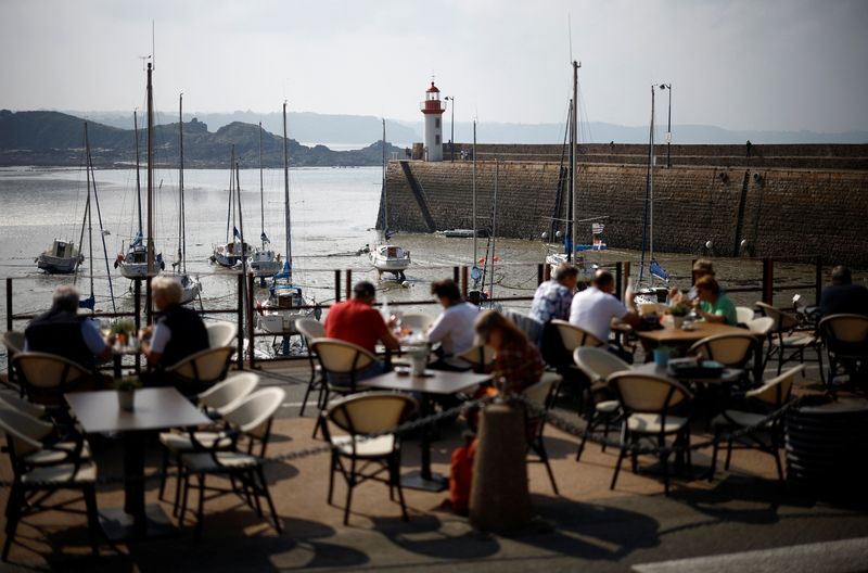 FILE PHOTO: People sit on the terrace of a restaurant in front of the harbour of Erquy, Brittany, France, September 19, 2024. REUTERS/Stephane Mahe/ File Photo
