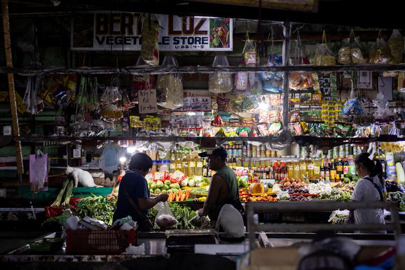 FILE PHOTO: A vendor tends to a customer at a public market in Quezon City, Metro Manila, Philippines, October 4, 2024. REUTERS/Eloisa Lopez/ File Photo