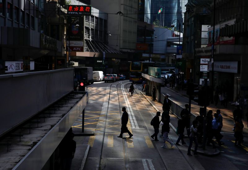 FILE PHOTO: Pedestrians are silhouetted as they cross a street in Hong Kong, China January 6, 2020. REUTERS/Navesh Chitrakar/File Photo