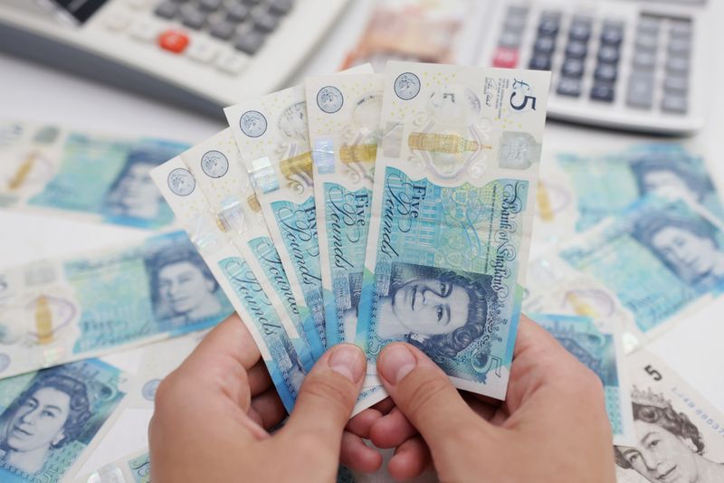 FILE PHOTO: Woman holds British Pound banknotes in this illustration taken May 30, 2022. REUTERS/Dado Ruvic/Illustration/File Photo
