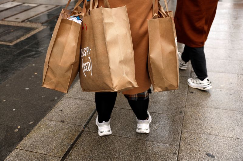 FILE PHOTO: A shopper holds several bags after coming out of a clothing store in central Madrid, Spain, April 28, 2022. REUTERS/Susana Vera/ File Photo