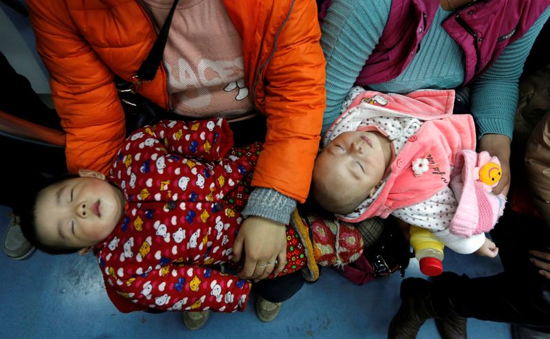 FILE PHOTO: Women hold their babies in a subway train in Beijing, March 1, 2013. REUTERS/Kim Kyung-Hoon/File Photo