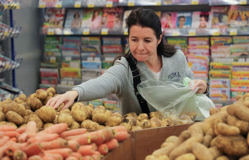 FILE PHOTO: A customer picks potatoes at a supermarket in Saint Petersburg, Russia May 30, 2025. REUTERS/Anton Vaganov/File Photo